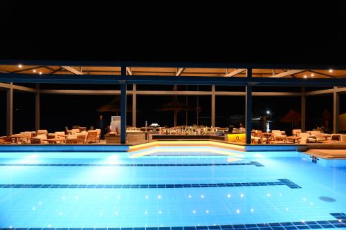 a large swimming pool at night with a restaurant at Samara Hotel Bodrum Ultra All Inclusive in Torba