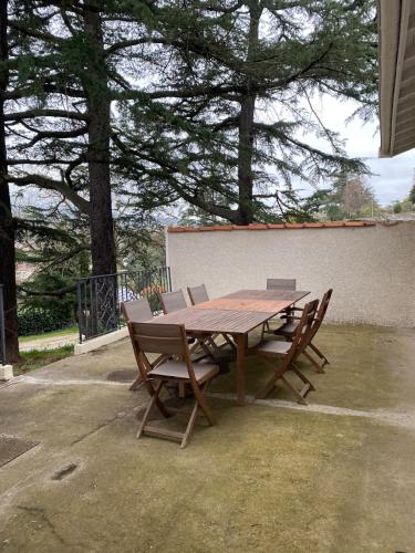 a wooden table and chairs sitting on a patio at Saint-Denis 1910 in Annonay