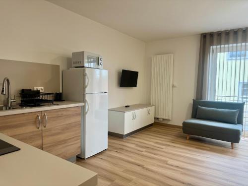a kitchen with a white refrigerator and a blue chair at Apartment, Zimmer, Ferienwohnung in Traitsching