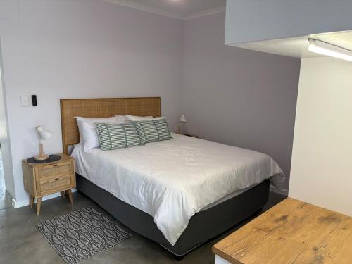 ein Schlafzimmer mit einem großen Bett und einem Nachttisch in der Unterkunft Comfy Cottage in Walvis Bay