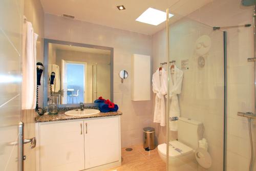 y baño con ducha, lavabo y aseo. en Hotel Altamar, en Puerto Rico de Gran Canaria