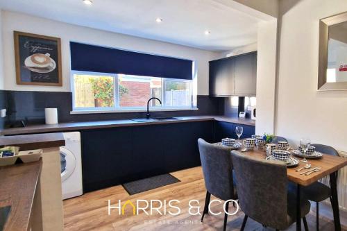a kitchen with a dining table and a kitchen with a sink at The Poulton Paradise in Poulton le Fylde