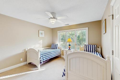 Zimmer mit 2 Betten und einem Deckenventilator in der Unterkunft Tupelo Cottage in Hilton Head Island