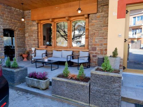 a patio with furniture and plants in front of a building at Aurora al Lago in Canzolino