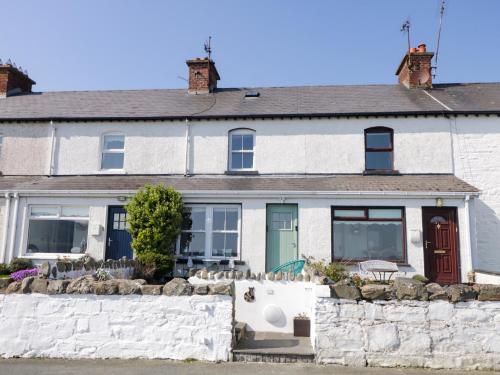 a white house with a stone wall at 3 Coastguard Station in Rathmullan