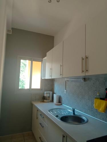 une cuisine avec un évier et une fenêtre dans l'établissement christiane cere, à Amélie-les-Bains-Palalda