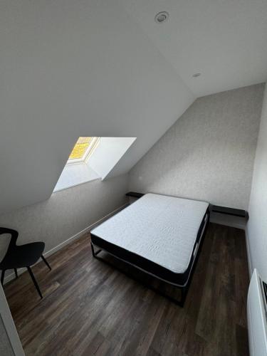 une chambre avec un lit et une lucarne dans l'établissement Le Gîte de la vilaine, à Sainte-Anne-sur-Vilaine