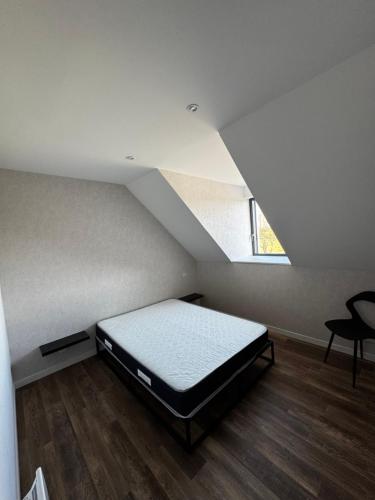 une chambre avec un lit dans un grenier dans l'établissement Le Gîte de la vilaine, à Sainte-Anne-sur-Vilaine