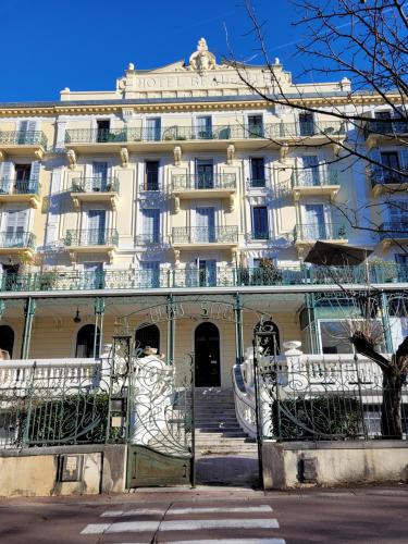 un grand bâtiment blanc avec des escaliers devant lui dans l'établissement Résidence Le Beau site Studio Rénové, à Aix-les-Bains