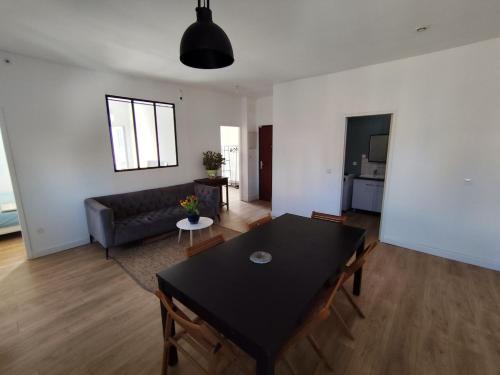un salon avec une table noire et un canapé dans l'établissement Authentic neighborhood! Central, à Sète