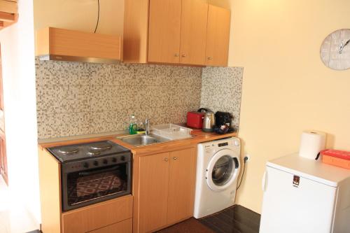 a kitchen with a sink and a washing machine at Main square apartment in Symi