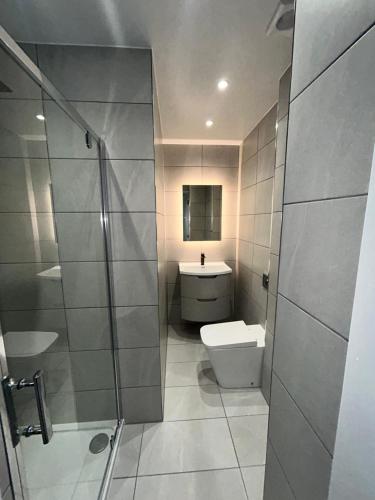 a bathroom with a toilet and a shower and a sink at Crookston Hotel in Glasgow