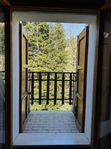 an open door leading to a porch with trees at Dolce Rifugio sul Castello - Incantevole appartamento a due passi dal centro con Garage in Sestola