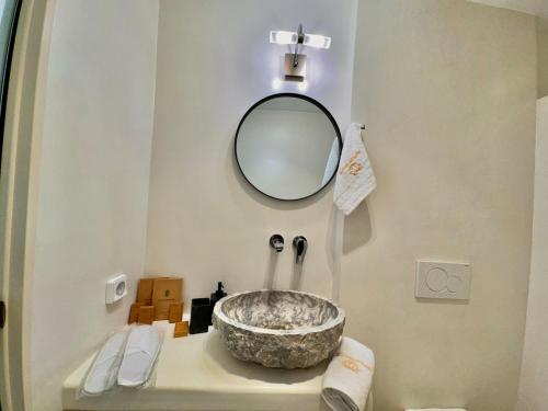 a bathroom with a bowl sink and a mirror at La vie est belle Luxury Residence With Jacuzzi 1 in Pounda
