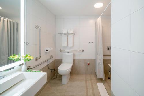 a white bathroom with a toilet and a sink at Beach Park Resort - Suites in Aquiraz