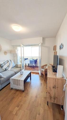 un salon avec un canapé et une table dans l'établissement E comme Eden, 2 pièces vue mer loggia et parking, à Villers-sur-Mer