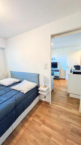 une chambre avec un lit bleu et un miroir dans l'établissement E comme Eden, 2 pièces vue mer loggia et parking, à Villers-sur-Mer