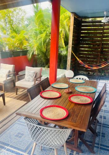 a wooden table with plates and chairs on a patio at Villa Victoria in Bouillante
