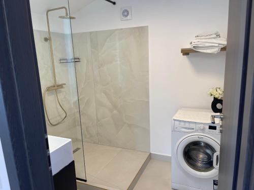 a shower in a bathroom with a washing machine at Happy apartment 2 in Chiajna