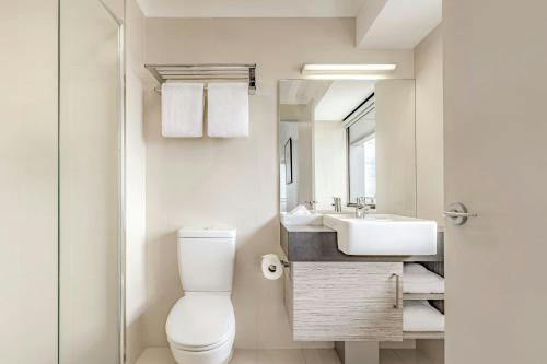 a bathroom with a toilet and a sink at Courtyard by Marriott Darwin in Darwin