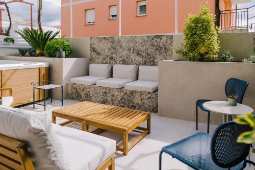 a patio with a bench and tables and chairs at Apartments Toni in Split