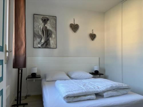 - une chambre avec un lit et une photo de femme dans l'établissement Appartement avec piscine, à Grandcamp-Maisy
