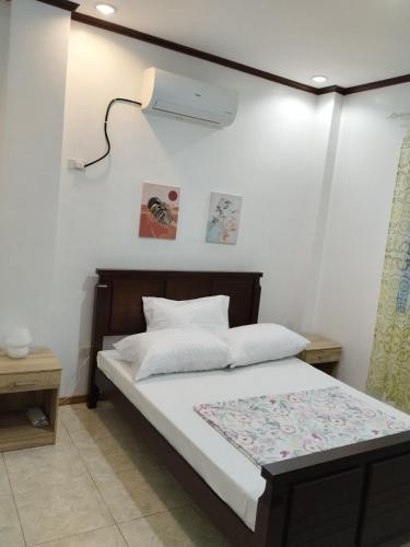 a bedroom with a bed with a light on the wall at Bungalow in Bagacay Island