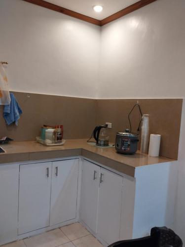 a kitchen with white cabinets and a counter top at Bungalow in Bagacay Island