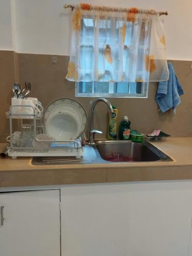 a kitchen sink with a dish drying rack next to it at Bungalow in Bagacay Island