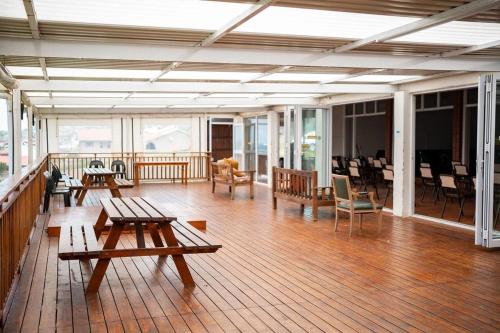 a large room with tables and chairs on a wooden floor at Transhaven Seaside Home in Durban