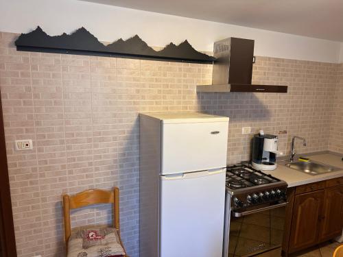 a kitchen with a white refrigerator and a stove at Il nido d'Ala in Ala di Stura