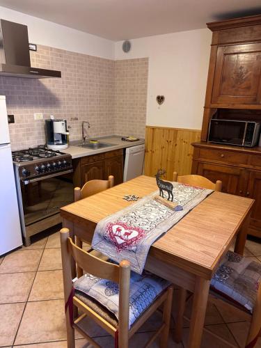 a kitchen with a wooden table with a cat napkin on it at Il nido d'Ala in Ala di Stura