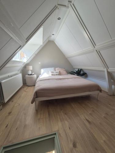 a bedroom with a bed in the attic at Vlier aan zee in Katwijk aan Zee