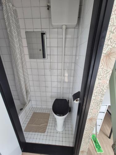 a small bathroom with a toilet with a black seat at Vlier aan zee in Katwijk aan Zee