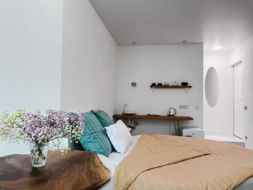 a bedroom with a vase of flowers on a table at Studia-Focus-Design in Aktobe