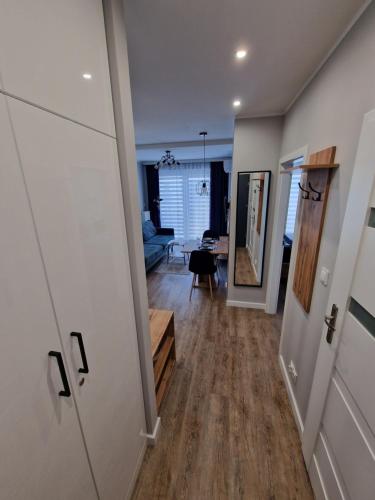un pasillo que conduce a una sala de estar con suelo de madera en Apartament Busko Odnova, en Busko-Zdrój