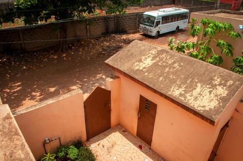 a bus parked in a parking lot with a building at Résidence ArconLuxe in Abomey-Calavi