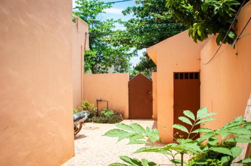 an orange building with a gate and some plants at Résidence ArconLuxe in Abomey-Calavi