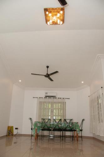 a dining room with a table and a ceiling fan at Résidence ArconLuxe in Abomey-Calavi