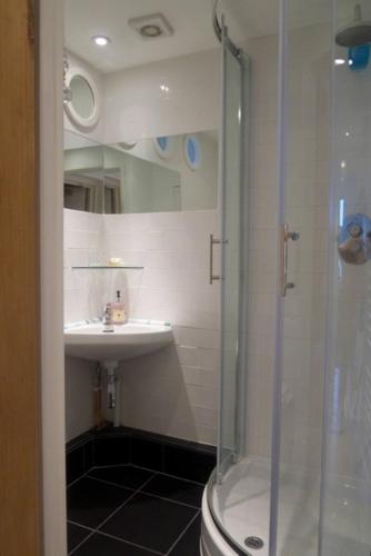 a bathroom with a shower and a sink at Flat One Harbour Street in Whitstable