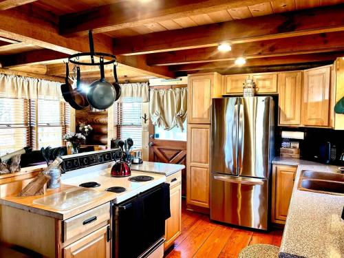 a kitchen with a stove and a refrigerator at Smoky Mountains Blue Ridge Cabin Tennessee in Maryville