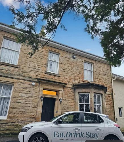 a car parked in front of a brick house at Crookston Hotel in Glasgow