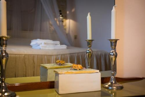 a table with two candlesticks and a candle on it at Appartamenti turistici Vicolo S. Chiara in Sassoferrato