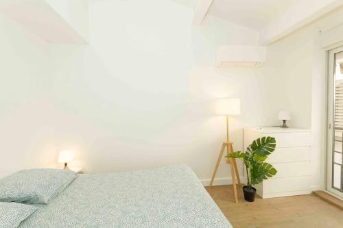 - une chambre blanche avec un lit et une plante dans l'établissement Loft center & terrace & air conditioning, à Marseille