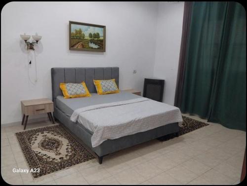a bedroom with a bed with yellow pillows on it at DarNour in ‘Alāqimah