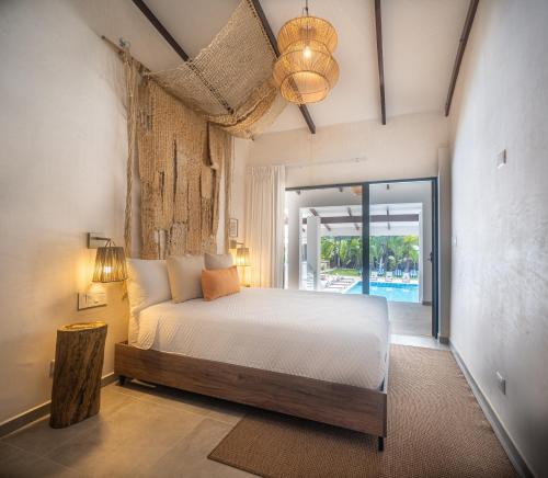 a bedroom with a bed and a view of a pool at Lia Hotel Jaco in Jacó