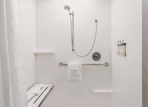 a white bathroom with a shower and a toilet at Holiday Inn Express & Suites Ormond Beach - North Daytona by IHG in Ormond Beach