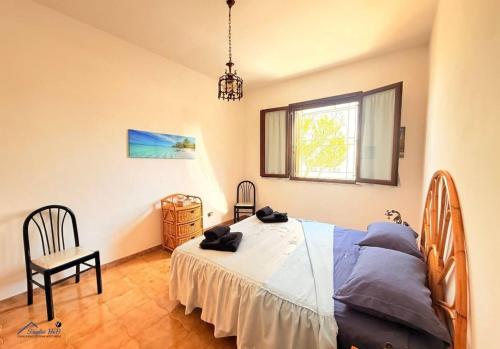a bedroom with a bed and a chair and a window at Residenza Marechiaro in Paparella