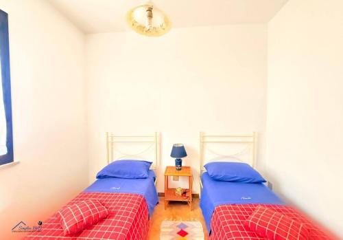 two twin beds in a bedroom with a table at Residenza Marechiaro in Paparella