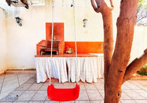 a red chair chained to a table next to a tree at Residenza Marechiaro in Paparella